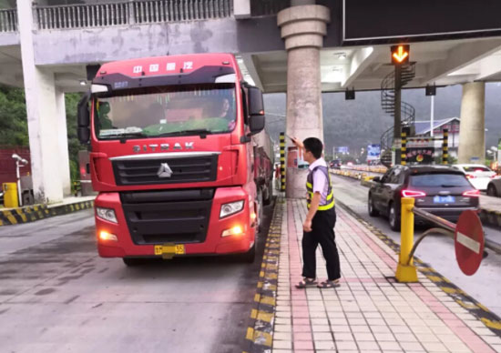 圖為收費班長引導(dǎo)該車駛出收費站